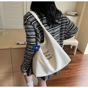 Détail du sac fourre-tout minimaliste en toile crème avec lettrage noir artistique
