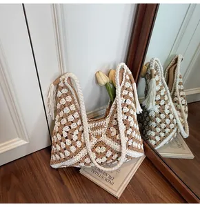 Detail of hand-woven crochet tote bag with geometric pattern and rope handle tassels