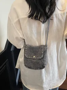 Retro grey denim crossbody messenger bag with metal buckle shown on a model