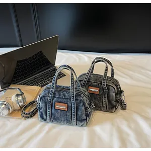 Close-up of vintage denim bowling bags in blue and grey with brown leather patches