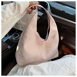 Detail of pink embroidered hobo bag with gold butterfly and bamboo leaf motifs