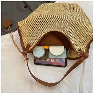 Detail of spacious straw tote bag showing internal storage for tablets and cosmetics