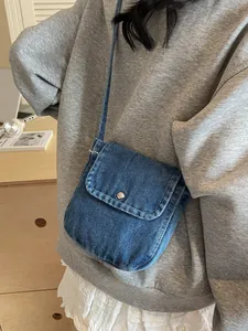 Vintage denim flap messenger bag for women worn by a model in a casual daily setting