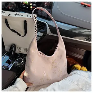 Detail of light purple tote bag with golden butterfly embroidery in a luxury car interior