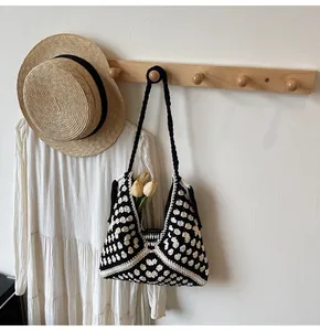 Close-up of handmade crochet tote bag featuring black and white checkerboard knit pattern