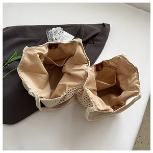 Detail view of woven straw tote bags showing fabric lining and magnetic leather closure