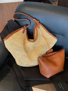 Large straw tote bag with brown leather handles and matching inner pouch on a dark seat