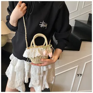 Détail du sac en paille avec dentelle blanche, breloques tulipes et cordon de serrage