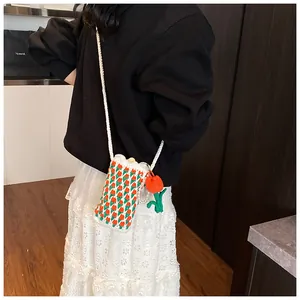 Close-up of hand-crocheted tulip crossbody bag with pearl charms and wooden button