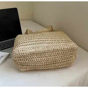 Gros plan sur la texture du sac en paille tissée montrant le matériau beige naturel