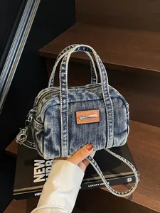 Vintage denim bowling handbag with adjustable strap and brown leather patch detail