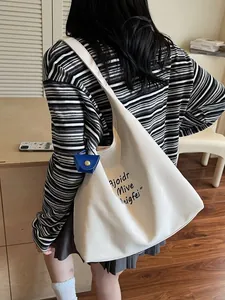 Grand sac fourre-tout minimaliste en toile crème avec lettrage noir et petit pendentif bleu