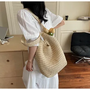 Détail d'un grand sac cabas en paille tressée avec tulipes pour un style de vacances