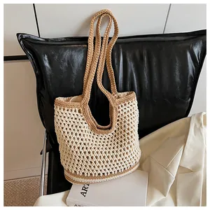 Detail of hand-woven crochet tote bag with mesh design and contrasting brown shoulder straps