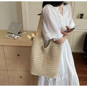 Détail du sac de plage beige au crochet montrant la texture de tissage en maille ajourée