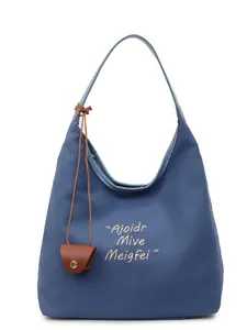 Sac fourre-tout minimaliste en toile bleue avec broderie et charm en cuir marron