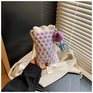 Close-up of handmade crochet tulip phone bag with wave patterns and a wooden button closure