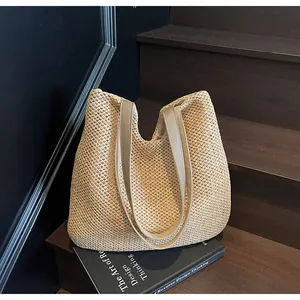 Close-up of the hollow weave texture and beige straps on this summer straw tote bag