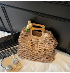 Close-up of khaki straw woven tote bag with a trapezoidal wooden handle and soft fabric lining