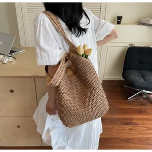 Détail d'un sac cabas en paille tissé main avec large bandoulière et intérieur spacieux