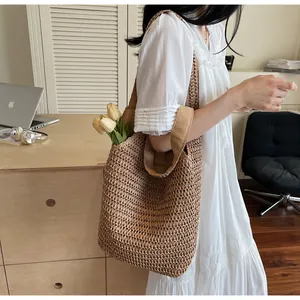 Détail du sac cabas en paille tissé à la main montrant l'intérieur et la texture maille