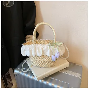 Détails de dentelle, ruban vert et bandoulière en perles sur sac de plage en paille