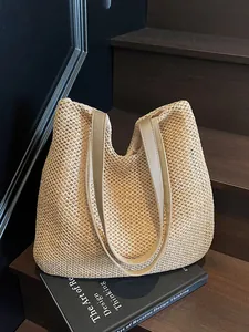 Minimalist straw woven tote bag with brown faux leather handles for summer beach vacation