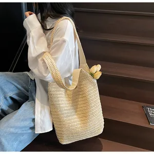 Gros plan détaillé sur la texture du sac cabas en paille avec tulipes jaunes