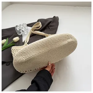 Close-up of cream crochet shoulder bag texture with tulip decor on a dark blazer