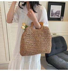 Detail of hand-woven straw tote bag with square wooden handles and spacious interior space