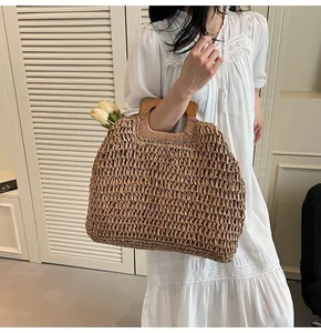 Close-up of handmade brown woven beach bag featuring ergonomic natural wooden handles