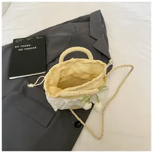 Détail du sac en paille avec bordure en dentelle, breloques tulipes et doublure intérieure