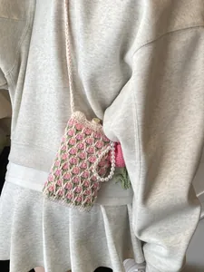 Handmade crochet crossbody phone bag with pink tulip patterns and pearl handle detail