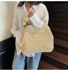 Detail of hand-woven straw tote bag with cutout mesh design and integrated handle