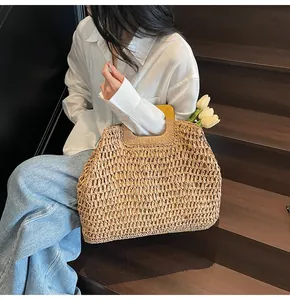 Detailed texture of hand-woven straw bag featuring a square wooden handle and hollow pattern
