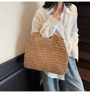 Close-up of a handwoven straw handbag featuring a polished natural wooden handle