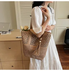 Detalle de bolso tote tejido con borlas de cuentas de madera y textura de malla única