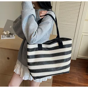 Detail of large woven tote bag with black and white stripes and thin shoulder straps
