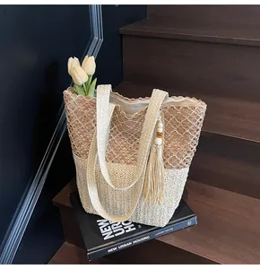 Vista detallada de la textura tejida bicolor y la borla en este bolso de playa tote