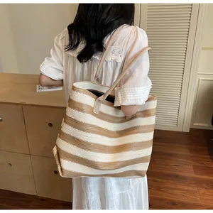 Detailed view of the woven stripe texture and large capacity on the straw tote bag
