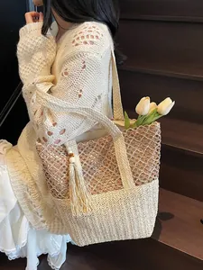 Bolso tote de paja en contraste con borla para vacaciones en la playa o diario