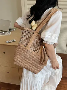 Bolso tote de paja tejida en marrón claro con borlas decorativas de cuentas de madera