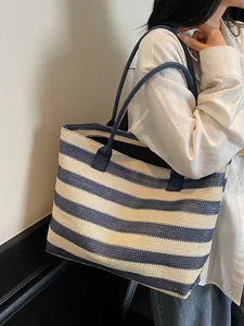 Blue and white striped straw tote bag with shoulder straps for beach and daily travel