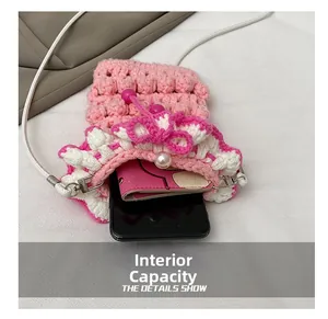 Macro shot of handmade crochet phone bag internal capacity with phone and small wallet