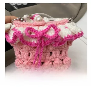 Close-up of handmade pink crochet bag featuring white wavy edges and a pearl button detail