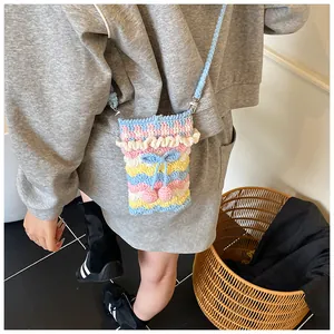 Detail der Strickstruktur einer bunten, handgefertigten Häkel-Umhängetasche mit Schleife