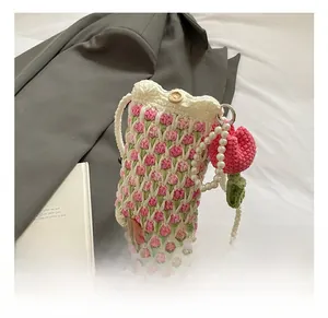 Detail view of handmade tulip crochet bag with wooden button and elegant pearl strap