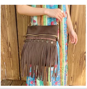 Detail of bohemian brown tassel bag with metallic accents and ethnic patterned strap