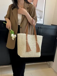 Große beige geflochtene Tragetasche mit braunen Ledergriffen und langen Quastenakzenten