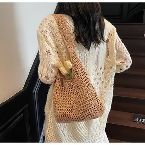 Gros plan sur le sac bandoulière en maille beige montrant la texture tissée ajourée
